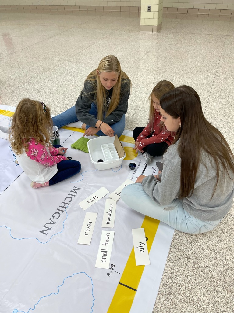 Mallorie Kneuvan and Keira Brown making maps with kindergarten students. 